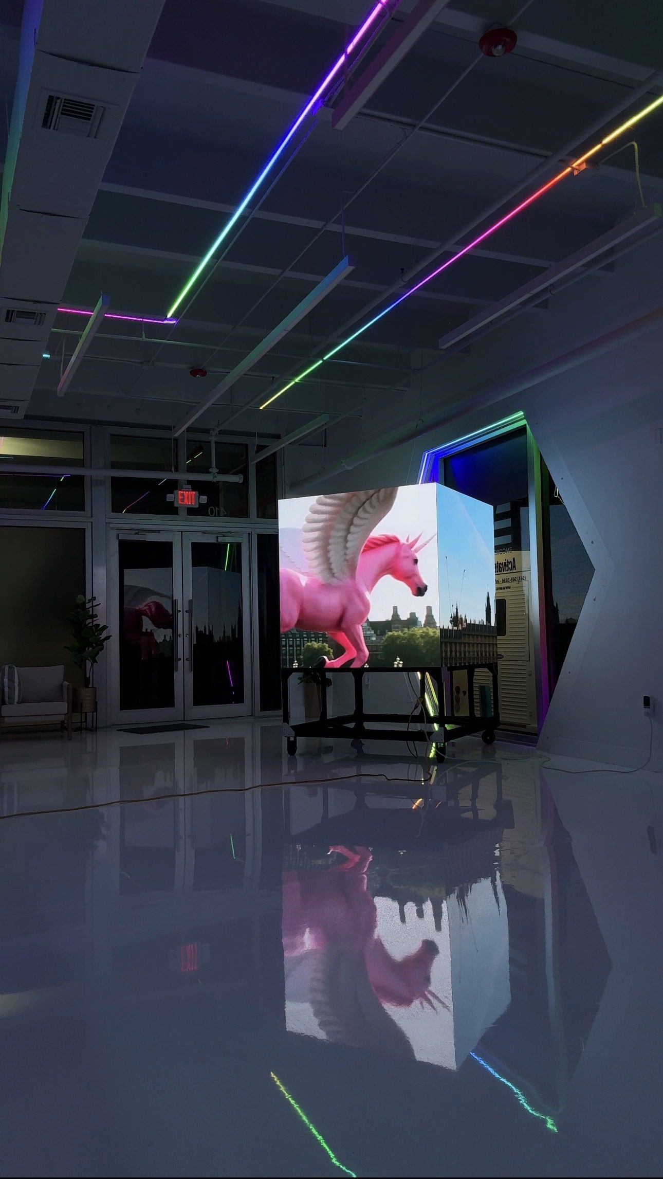 The movable digital cube at Encore Wynwood displaying content in a darkened room
